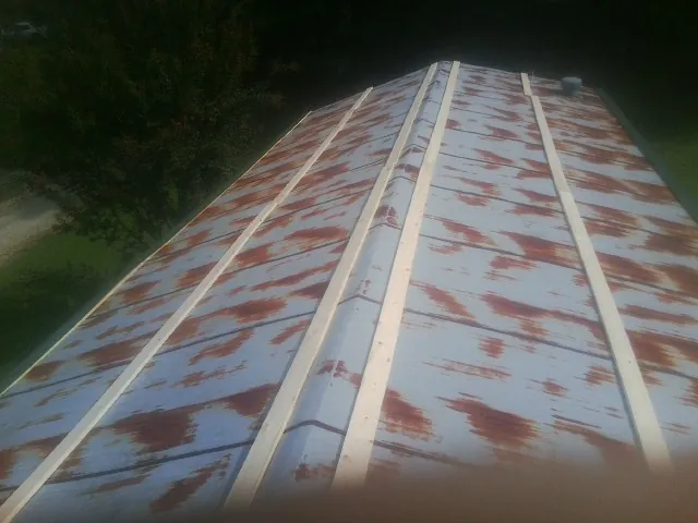 Rusted metal roof panels with new wood purlins before replacement — Storm Damage Roof Repair in Altamonte Springs by Roofing Brothers